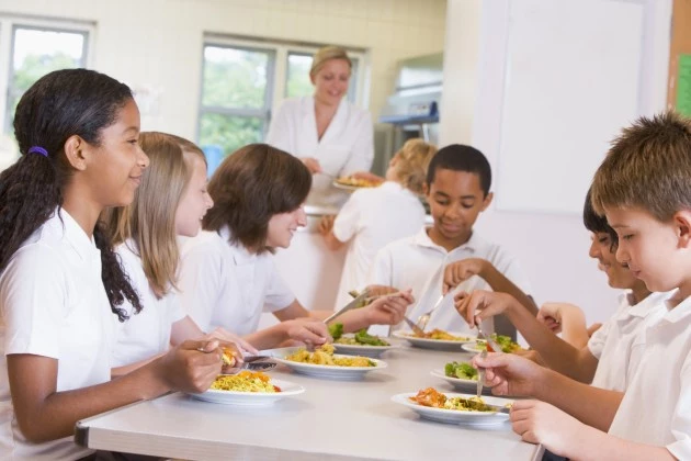 Schoolchildren enjoying their lunch in a school cafeteria Schoolchildren enjoying their lunch in a school cafeteria